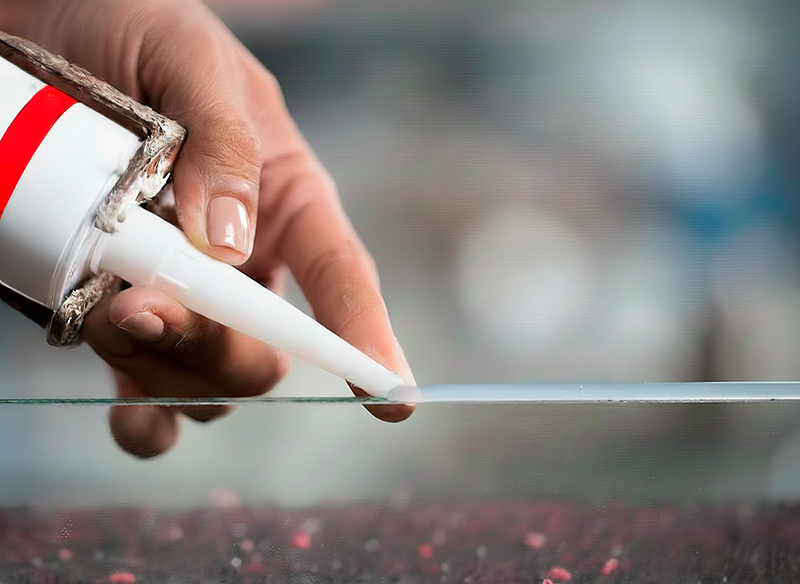 Нанесение силиконового герметика на шов стекла аквариума – клей-герметик для стекла, крупный план