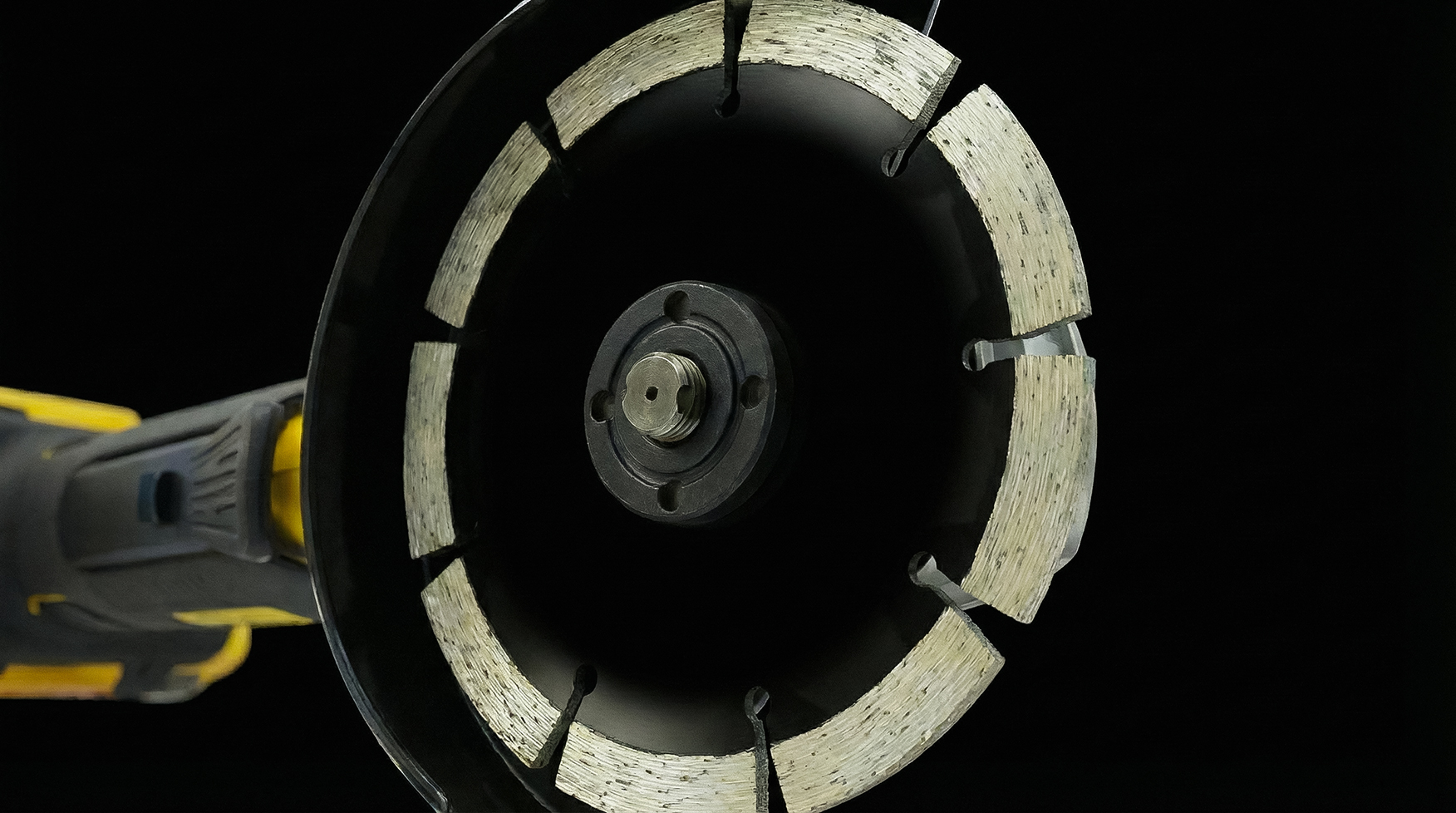 Сегментный алмазный диск для болгарки на черном фоне, крупный план Сегментный алмазный диск для болгарки на черном фоне, крупный план